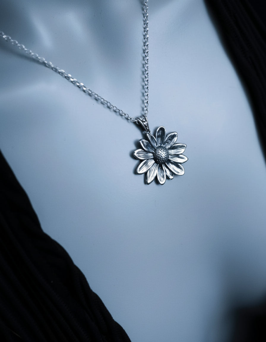 Silver daisy pendant necklace on a mannequin.